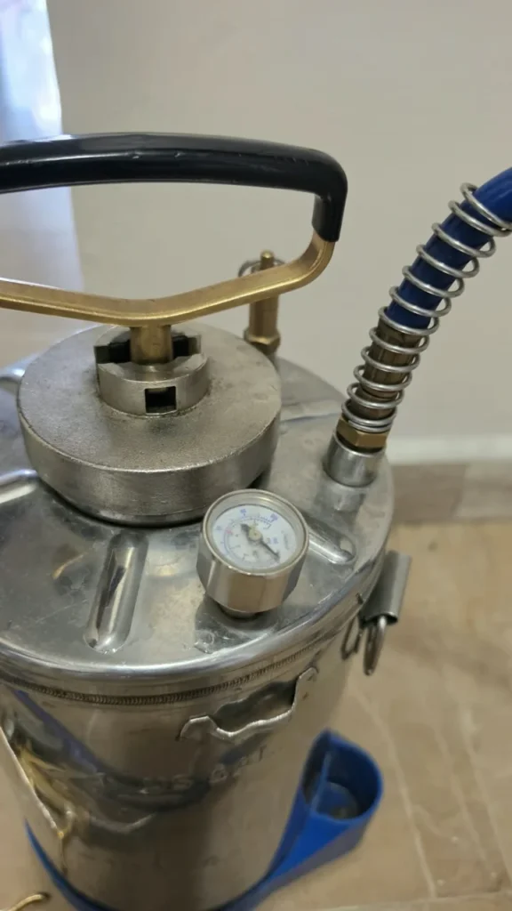 Detalle del manómetro, asa y conexión de manguera del aspersor real de SOLVEM.