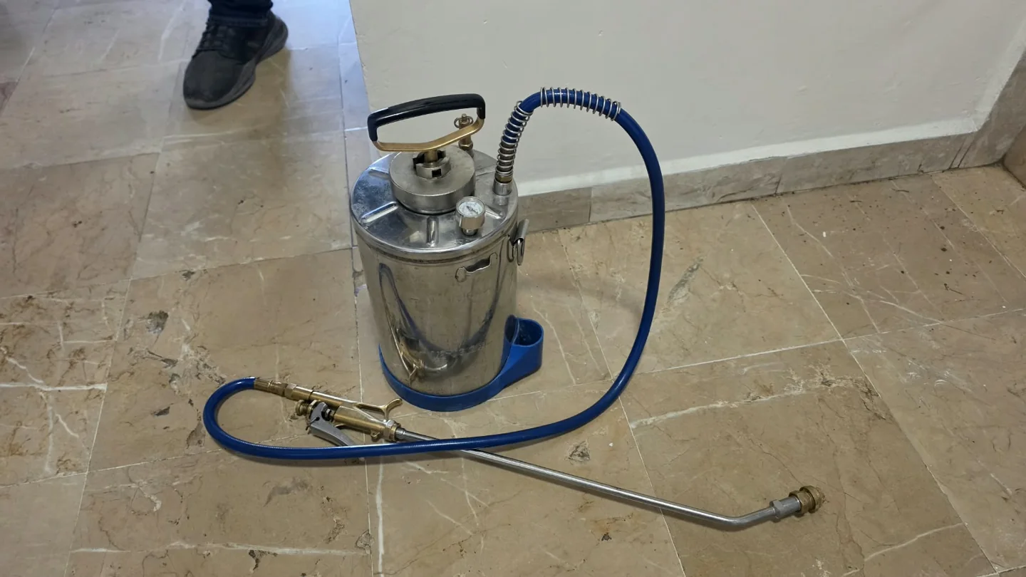 Aspersor de SOLVEM con tanque metálico, manómetro, manguera azul y lanza completa.